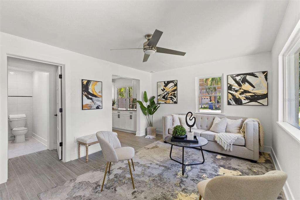 A living room features a beige sofa, two armchairs, a coffee table, and a ceiling fan — 6714 S FAUL STREET, TAMPA, FL