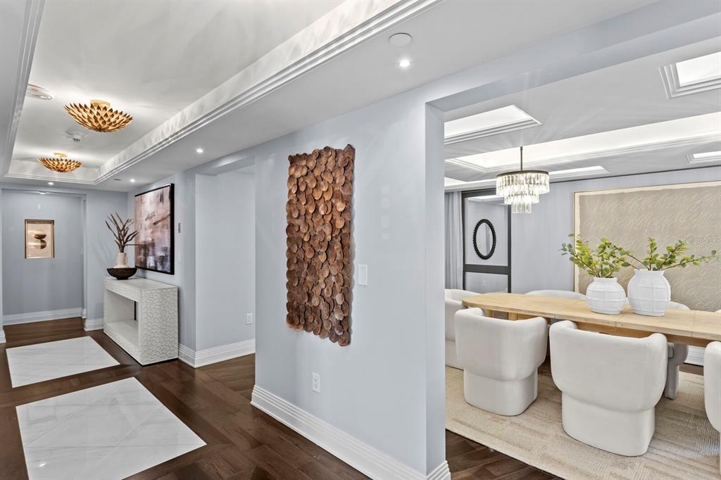 A hallway with marble floor insets leads to a dining room with white chairs — 3301 BAYSHORE BOULEVARD UNIT 2207B, TAMPA, FL