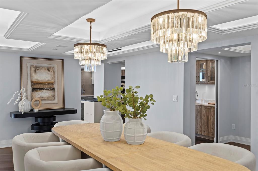 A dining room features a long wooden table, cream chairs, and two tiered crystal chandeliers — 3301 BAYSHORE BOULEVARD UNIT 2207B, TAMPA, FL