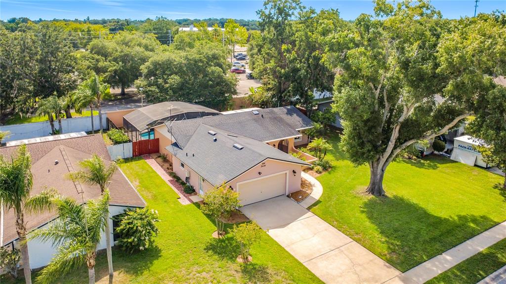 An aerial view of a single-story house with a garage, pool enclosure, and large trees — 5020 THE OAKS CIRCLE, ORLANDO, FL