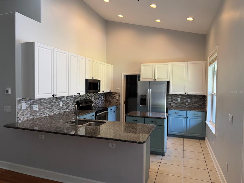 A single-story gray house with a shingled roof, dormer windows, and a front lawn — 14412 PINECONE ROAD, ORLANDO, FL