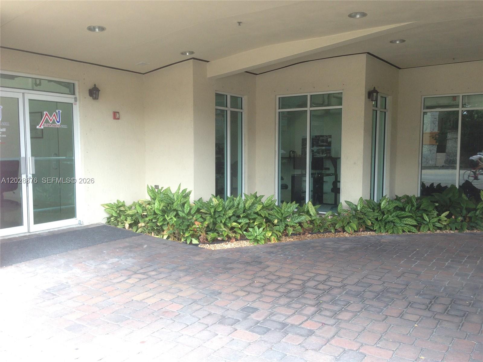 A paved driveway leads to the white exterior of a building with large glass windows — 1627 SW 37th Ave # 1, Miami FL 33145, MIAMI, FL