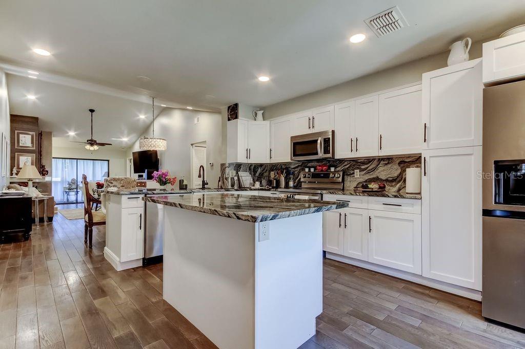 A kitchen with white cabinets, a large island, and dark granite countertops — 3163 LANDMARK DRIVE UNIT 623, CLEARWATER, FL
