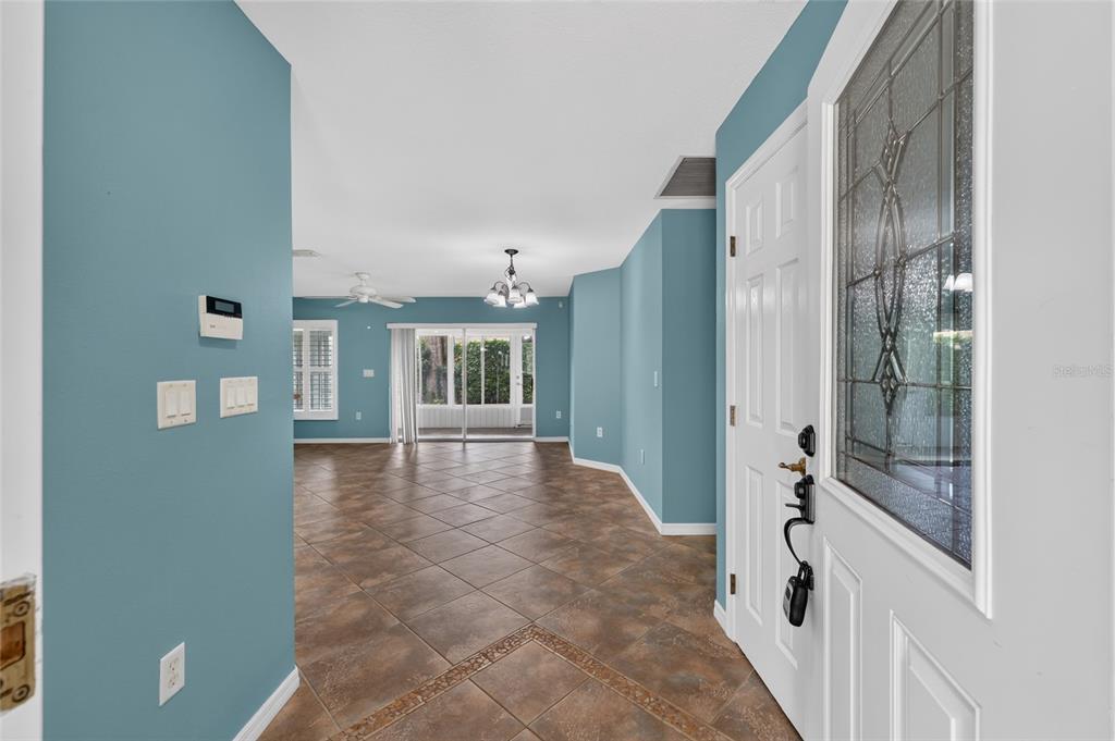 An entryway with tiled floors leads into a living room with blue walls — 7933 SW 83RD PLACE, OCALA, FL