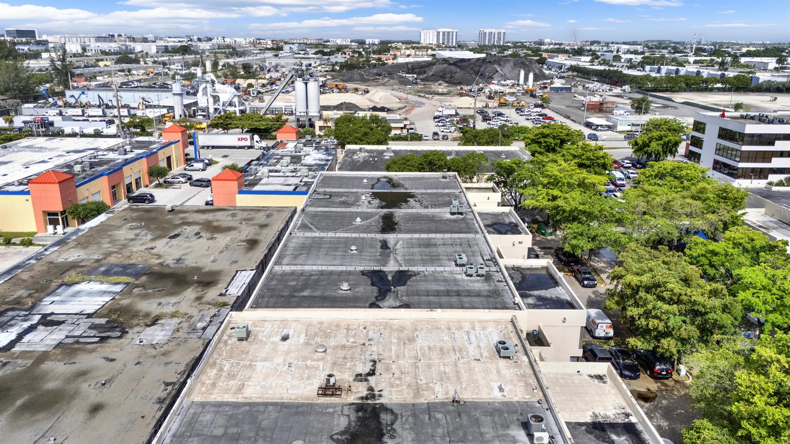 An aerial view shows the flat, weathered roofs of industrial buildings and surrounding parking lots — 7168 NW 50th Street, Miami FL 33166, MIAMI, FL
