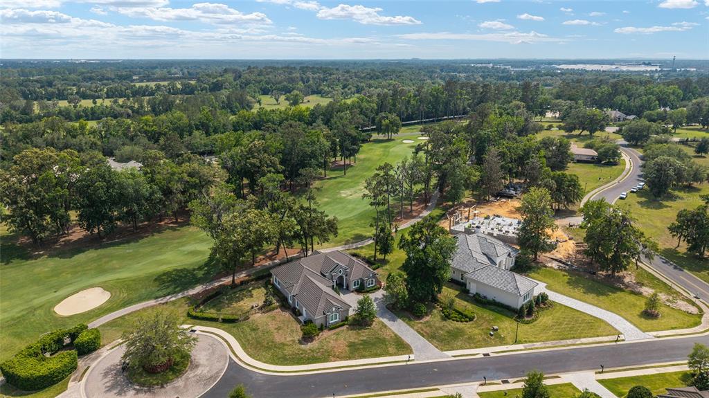 An aerial view shows two houses situated next to a golf course and a wooded area — 7554 NW 33RD PLACE, OCALA, FL