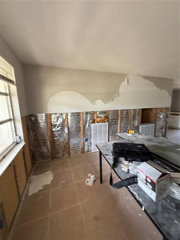A room undergoing renovation with exposed wall studs, insulation, and partially removed drywall — 8335 GULF WAY, HUDSON, FL