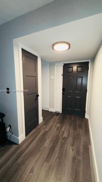 A hallway features wood-look flooring, a dark gray interior door, and a dark front door — 5800 CAMINO REAL # 306, Boca Raton FL 33433, BOCA RATON, FL