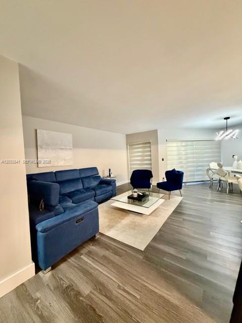 A living room features a blue sectional sofa, a coffee table, and wood-look flooring — 5800 CAMINO REAL # 306, Boca Raton FL 33433, BOCA RATON, FL