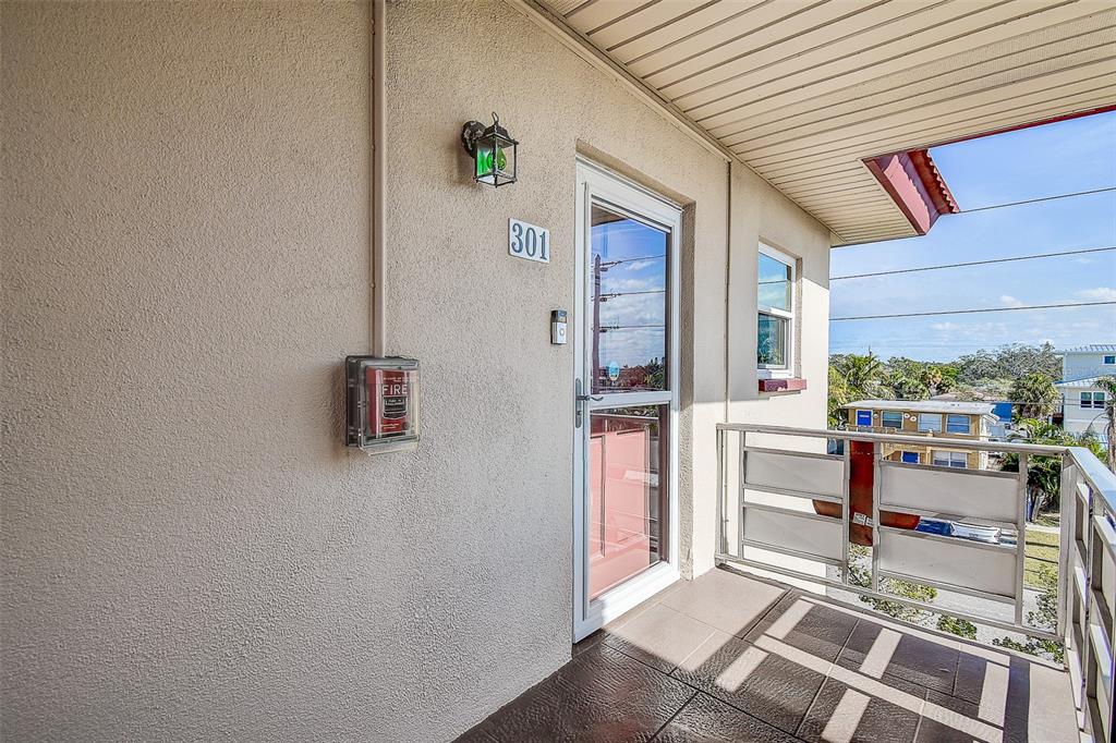 An exterior view of a balcony entrance with a door labeled 301 and fire alarm — 3010 59TH STREET S UNIT 301, GULFPORT, FL
