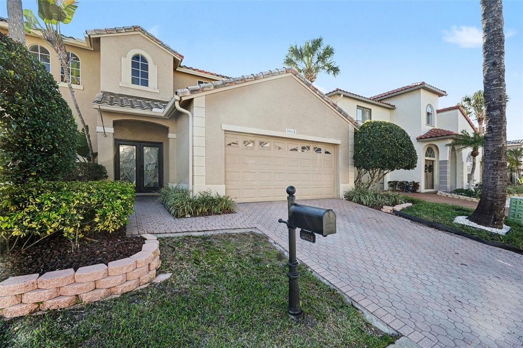 A backyard patio features a swimming pool with a stone waterfall and outdoor lounge furniture — 10618 HATTERAS DRIVE, TAMPA, FL