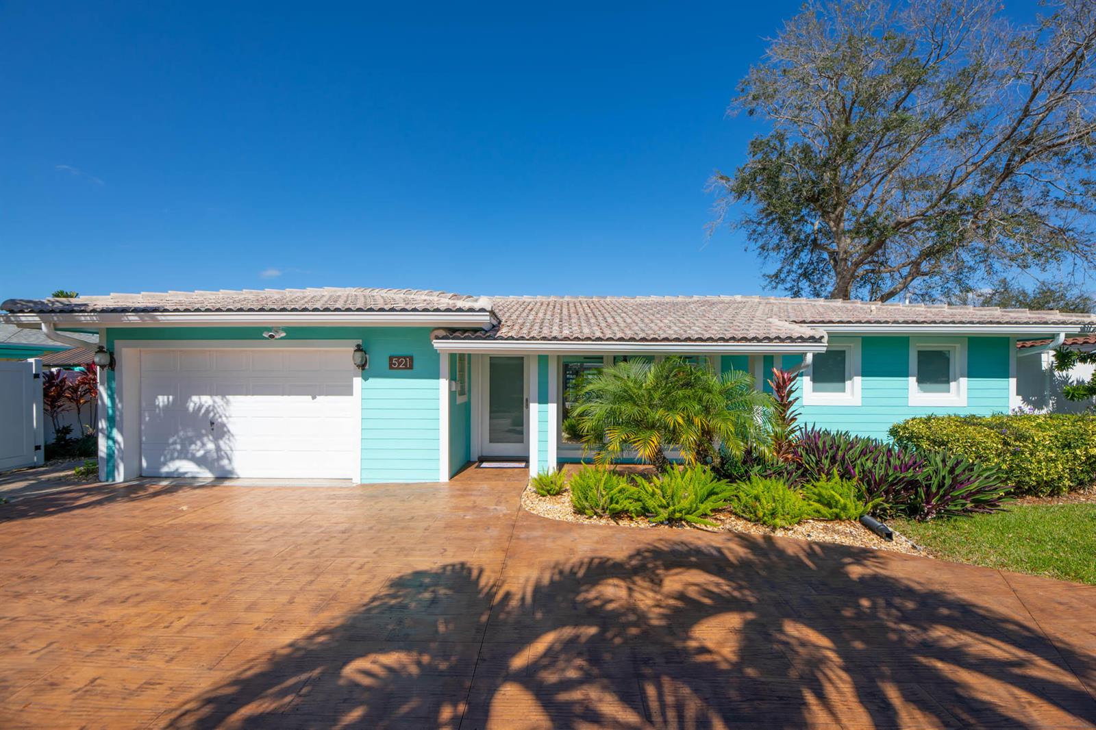 A single-story house with turquoise siding, a white garage door, and a stamped concrete driveway — 521 SE 4 Court, Pompano Beach FL 33060, POMPANO BEACH, FL