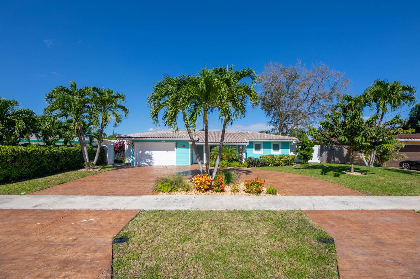 A turquoise single-story house features a stamped concrete driveway and several palm trees — 521 SE 4 Court, Pompano Beach FL 33060, POMPANO BEACH, FL