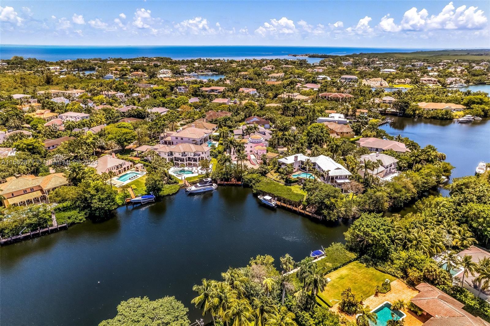 An aerial view shows waterfront luxury homes with swimming pools and private boat docks — 431 Costanera Rd, Coral Gables FL 33143, CORAL GABLES, FL