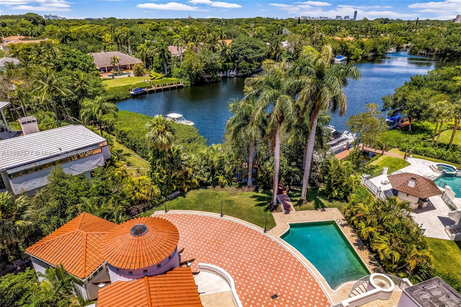 An aerial view shows a waterfront estate with a pool, patio, and boat docks — 431 Costanera Rd, Coral Gables FL 33143, CORAL GABLES, FL