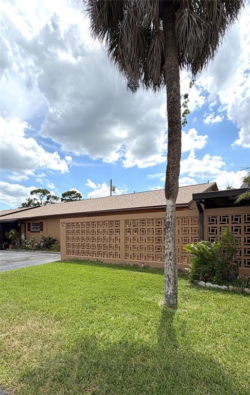 A single-story building features a decorative concrete block screen wall and a tall palm tree — 432 E STREET UNIT 432, CASSELBERRY, FL