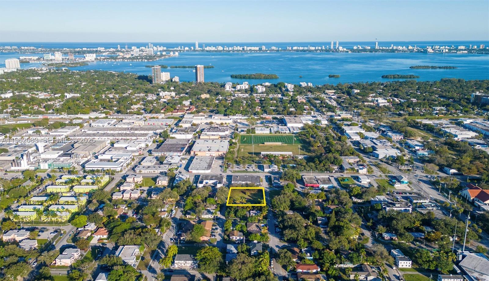 An aerial view shows a vacant rectangular lot outlined in yellow within a residential neighborhood — 159 NE 64th St, Miami FL 33138, MIAMI, FL