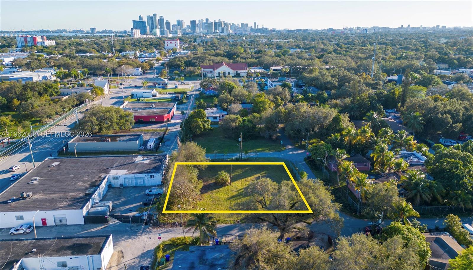 An aerial view shows a vacant, rectangular lot outlined in yellow near a city skyline — 159 NE 64th St, Miami FL 33138, MIAMI, FL