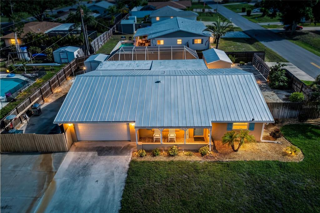 An aerial view of a single-story house with a metal roof and a front porch — 895 E BAFFIN DRIVE, VENICE, FL