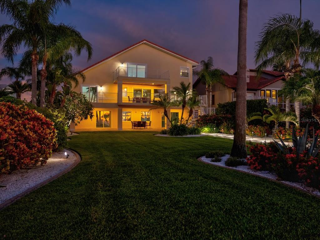 A boat lift and dock extend into the water under a colorful sunset sky — 5101 WESTSHORE DRIVE, NEW PORT RICHEY, FL