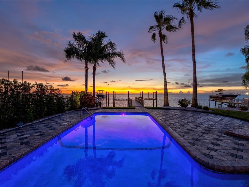 A multi-story house with balconies and a landscaped backyard at twilight — 5101 WESTSHORE DRIVE, NEW PORT RICHEY, FL