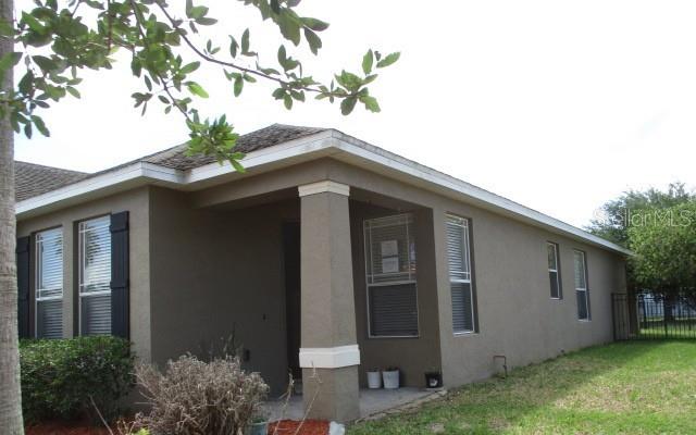 The exterior of a tan stucco house features a covered front porch with a square column — 3827 SPIRITED CIRCLE, ST CLOUD, FL