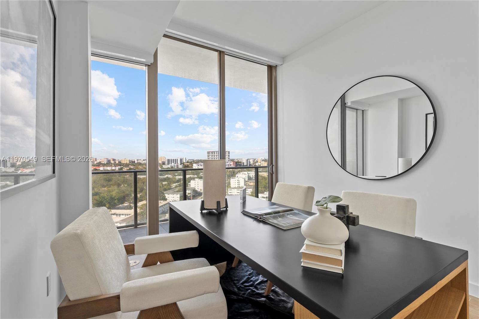 A modern home office features a black desk, two chairs, and a large window view — 2678 Tigertail Ave # 1202, Miami FL 33133, MIAMI, FL