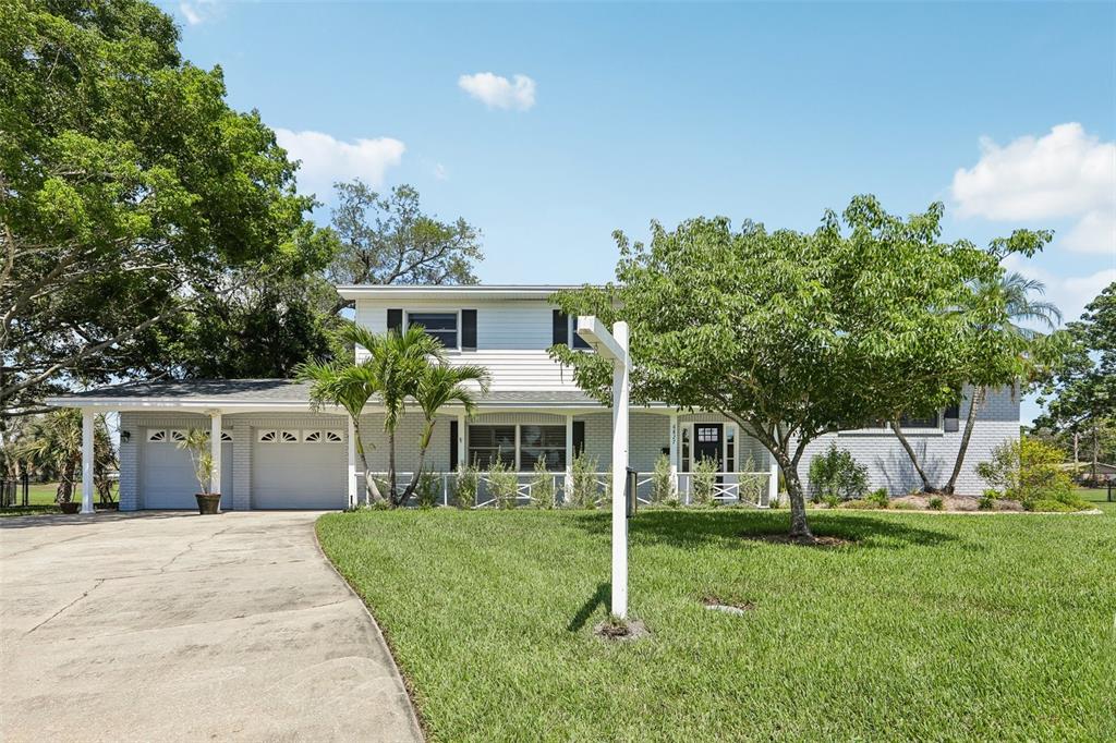 A two-story house with white siding, a two-car garage, and a large front lawn — 6827 TEQUESTA DRIVE, SEMINOLE, FL