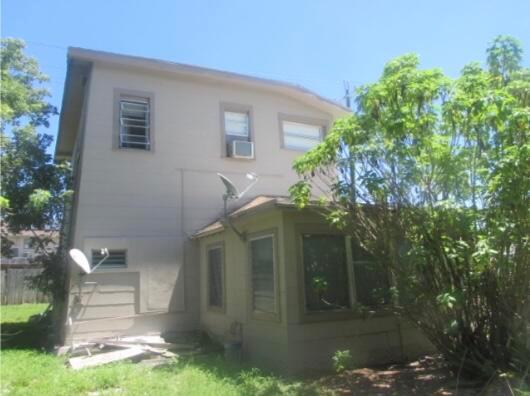 The exterior of a two-story house features a screened-in porch and a grassy yard — 402 N A Street, FL 33460, FL