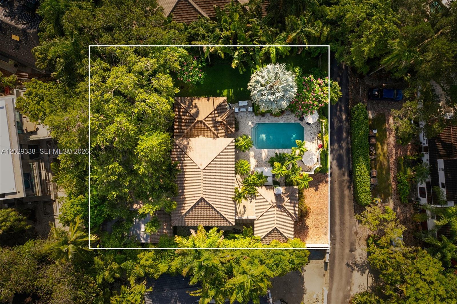 An aerial view shows a house with a tiled roof, swimming pool, and lush landscaping — 3845 Wood Ave, Miami FL 33133, MIAMI, FL