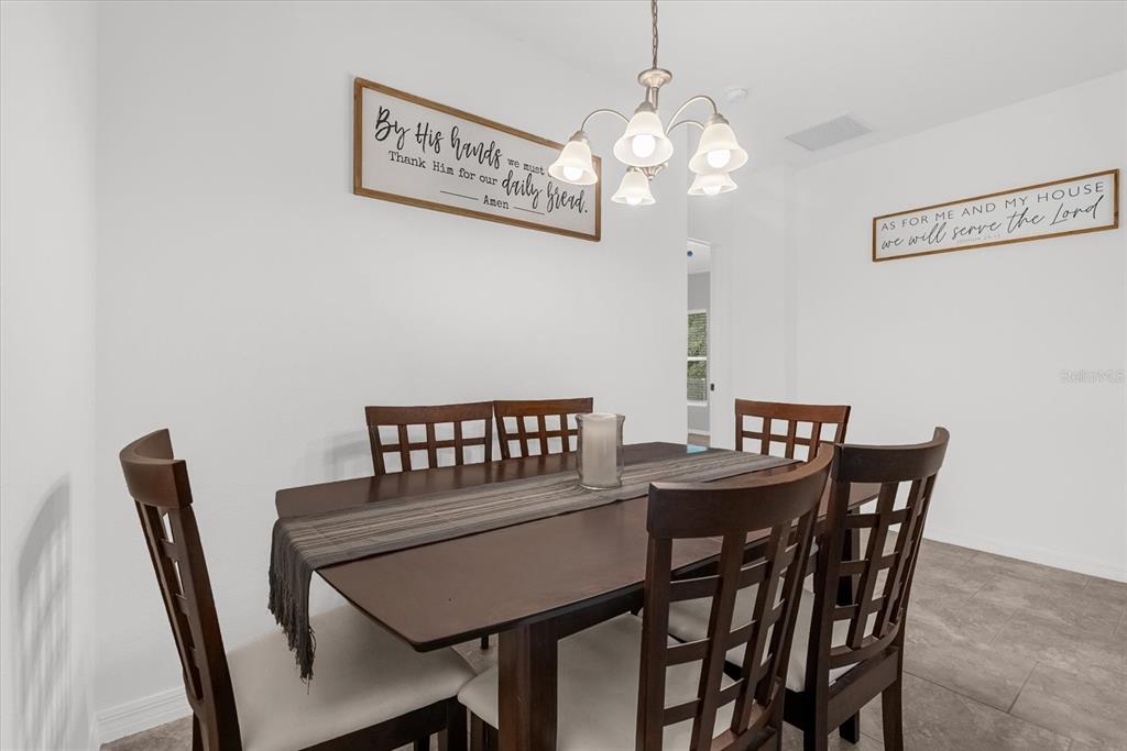 A dining room features a wooden table with six chairs, a chandelier, and two wall signs — 34625 SALERNO CIRCLE, SORRENTO, FL
