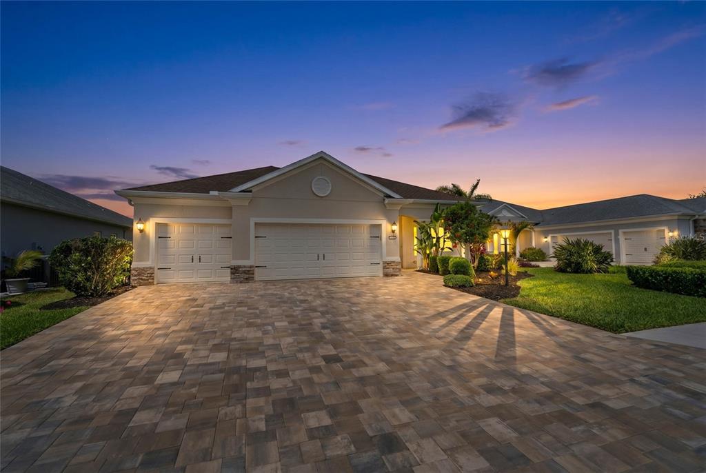 An open-concept kitchen and living area features white cabinetry, a kitchen island, and tile flooring — 1215 THORNBURY DRIVE, PARRISH, FL