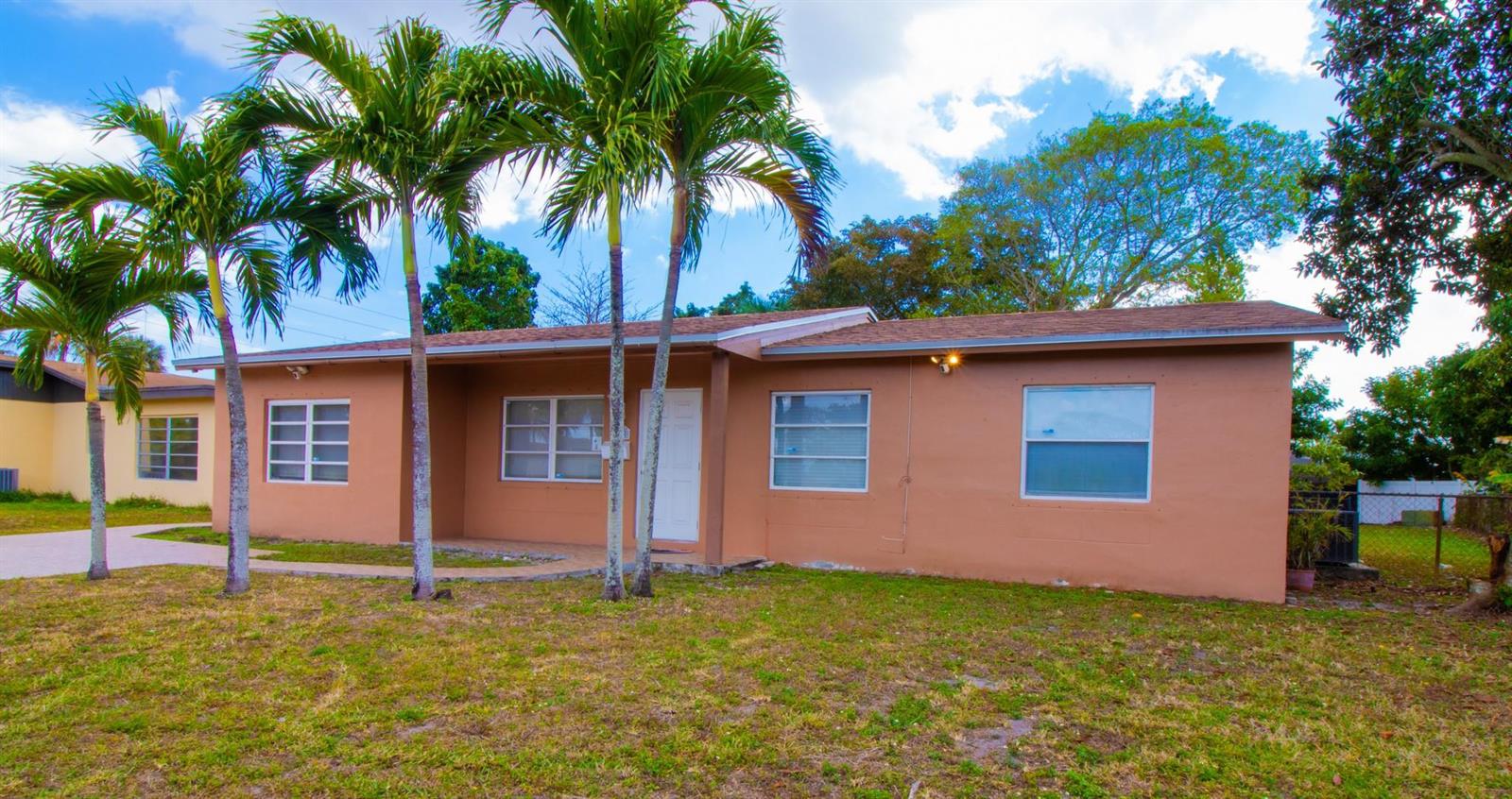 A single-story tan house with a brown roof and palm trees in the front yard — 6860 Broadmoor, North Lauderdale FL 33068, NORTH LAUDERDALE, FL