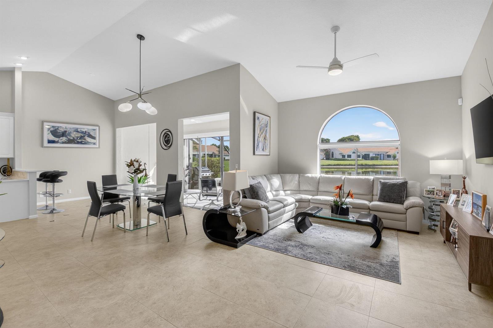A bright living and dining area features tile floors, a sectional sofa, and arched windows — 7400 Hearth Stone Avenue, Boynton Beach FL 33472, BOYNTON BEACH, FL