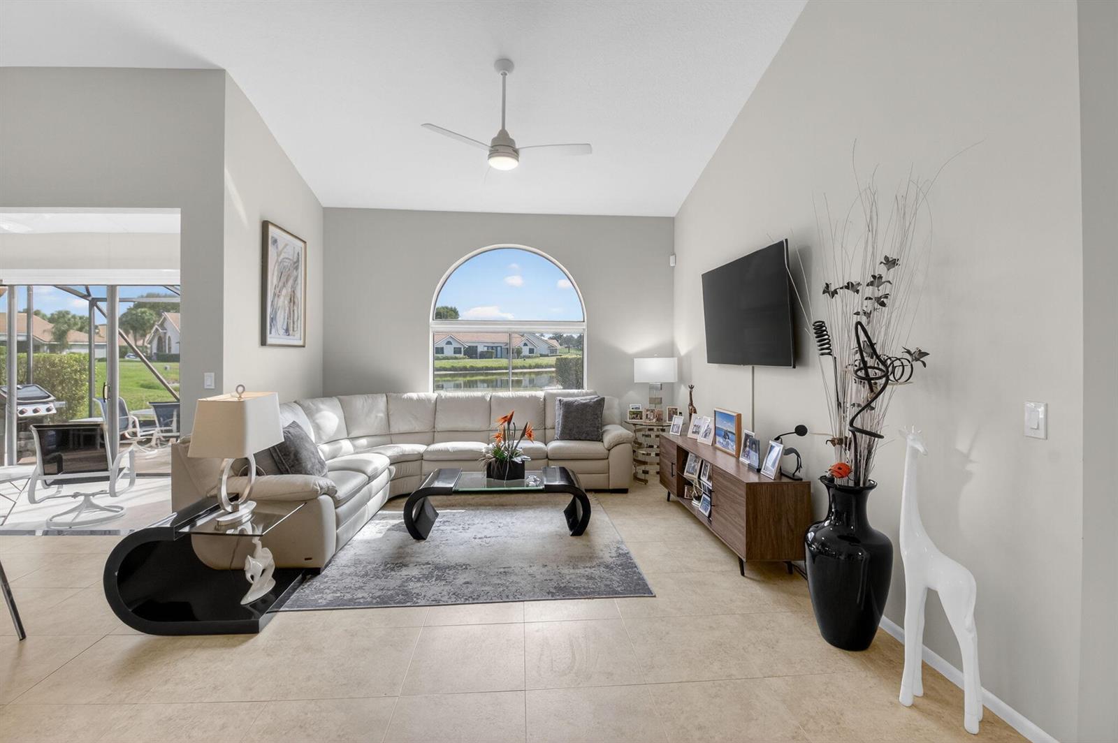 A living room features a white sectional sofa, a glass coffee table, and a large window — 7400 Hearth Stone Avenue, Boynton Beach FL 33472, BOYNTON BEACH, FL