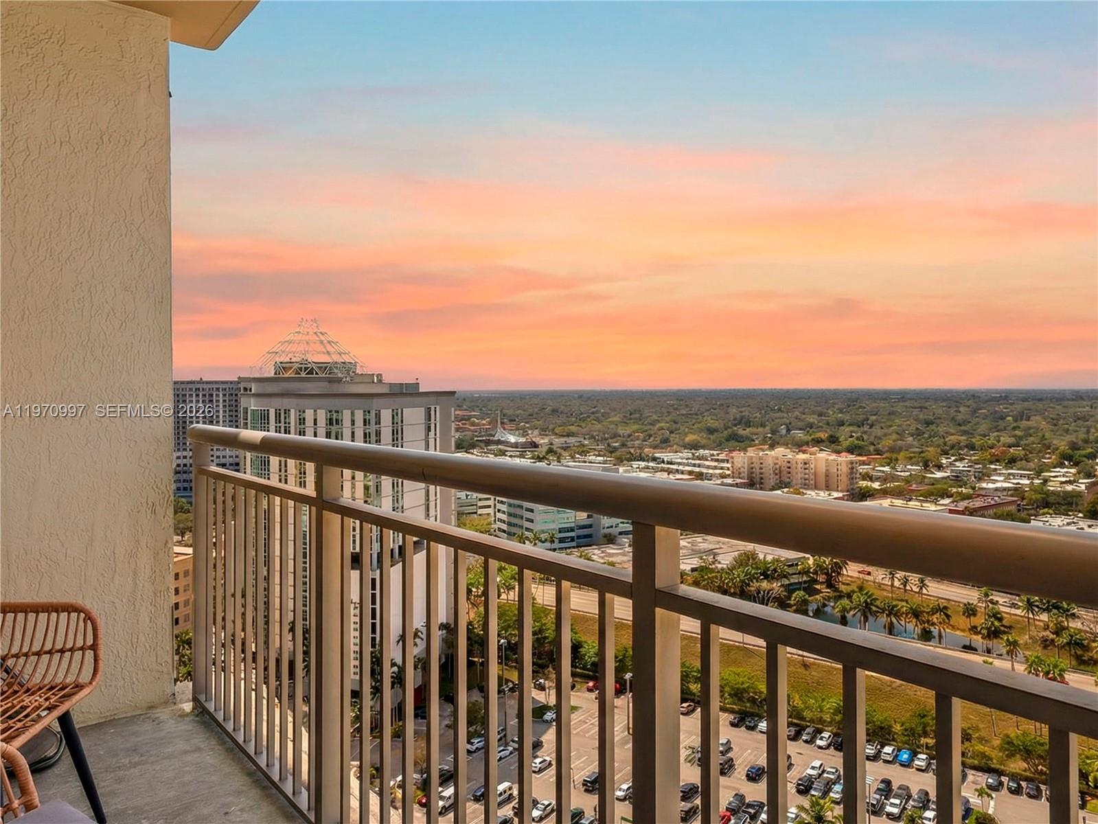 A high-rise balcony overlooks a parking lot and suburban landscape at sunset — 9066 SW 73rd Ct # 2008, Miami FL 33156, MIAMI, FL
