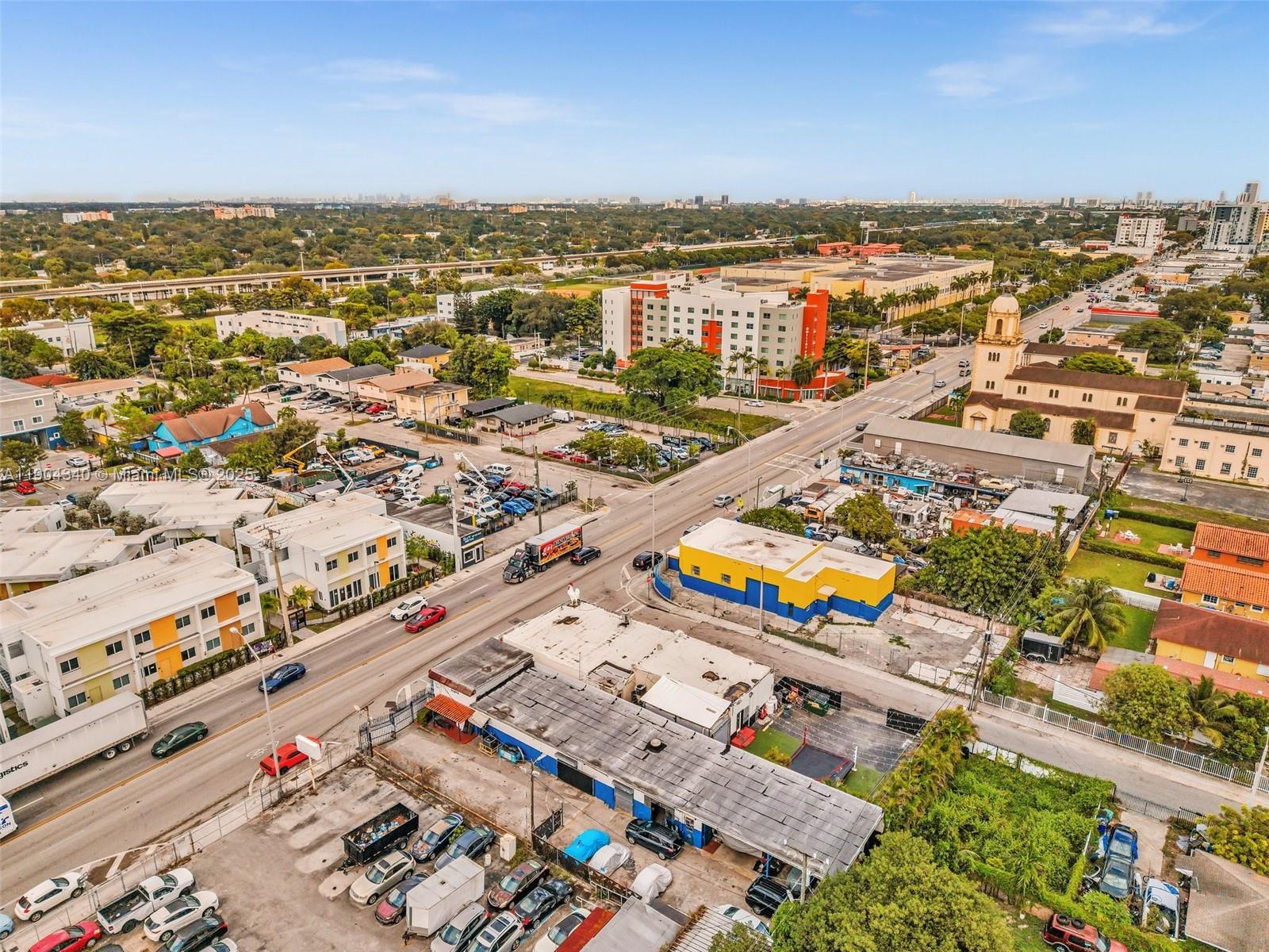 An aerial view shows a city street with commercial buildings, a church, and parked cars — 2112 NW 36th St, Miami FL 33142, MIAMI, FL