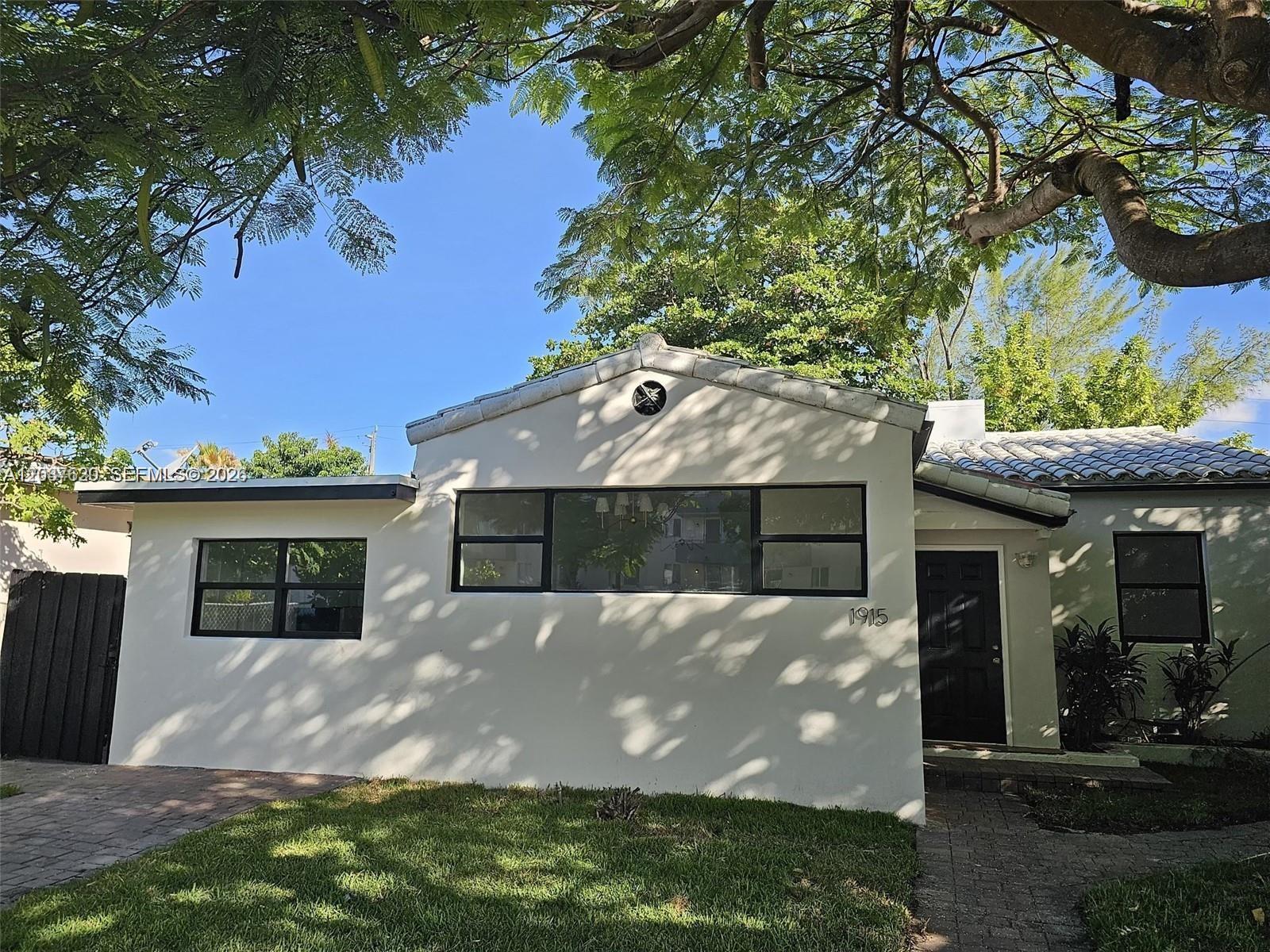 A single-story white stucco house with a tiled roof and black-framed windows — 1915 Normandy Dr, Miami Beach FL 33141, MIAMI BEACH, FL
