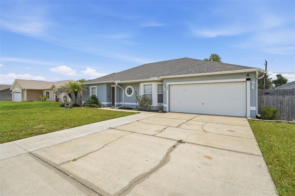 A single-story house with a gray exterior, a two-car garage, and a front lawn — 3088 WAINWRIGHT STREET, DELTONA, FL