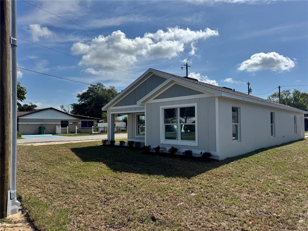 A newly constructed, light-gray single-story house with a front porch and a grassy yard — 6024 12TH STREET, ZEPHYRHILLS, FL