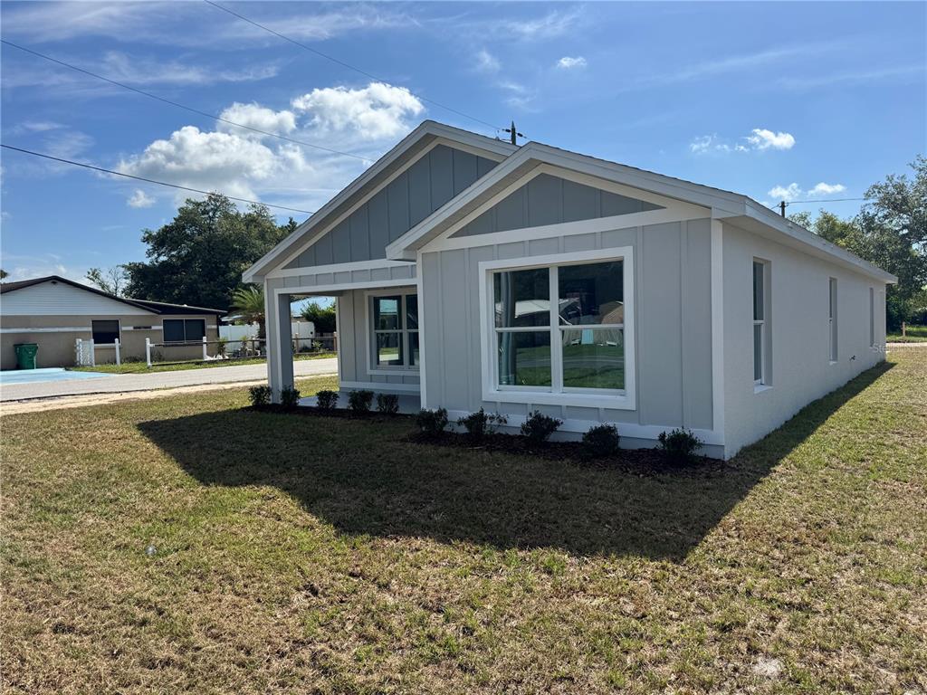 A light gray, single-story house with vertical siding and a covered front porch — 6024 12TH STREET, ZEPHYRHILLS, FL