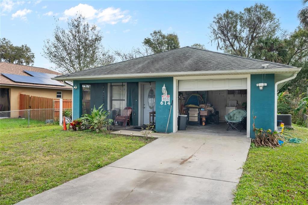A teal single-story house with a one-car garage and a concrete driveway — 614 WASHINGTON STREET, NEW SMYRNA BEACH, FL