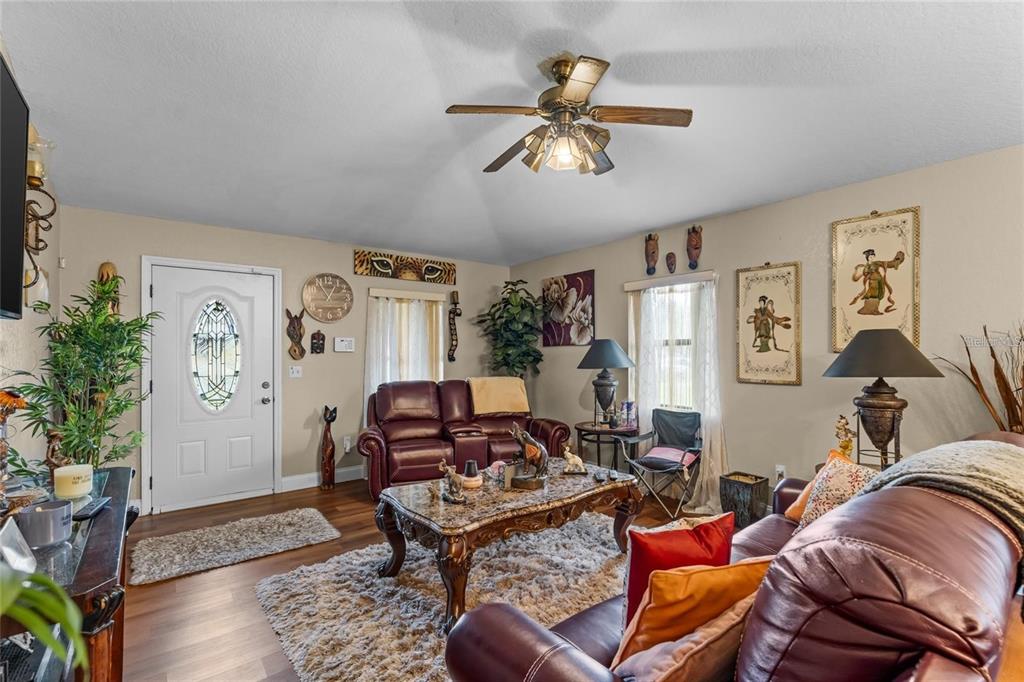 A living room features leather furniture, a marble coffee table, and a vaulted ceiling — 614 WASHINGTON STREET, NEW SMYRNA BEACH, FL