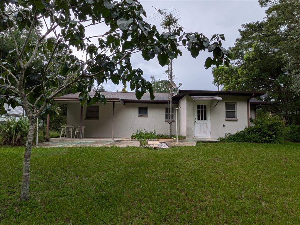 A single-story house with a white stucco exterior, a patio, and a grassy yard — 4316 SW DEEPWATER COURT, DUNNELLON, FL