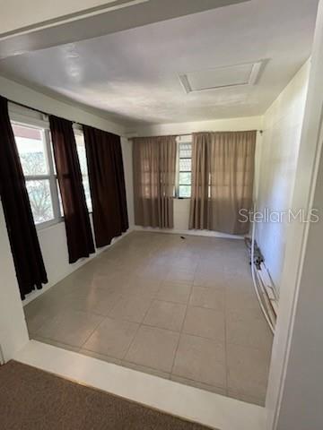 A sunroom with tile flooring, large windows with brown curtains, and a white ceiling — 4316 SW DEEPWATER COURT, DUNNELLON, FL