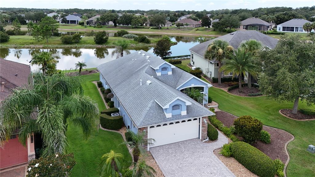 An aerial view of a blue house with a gray shingled roof and a garage — 2416 BAR HARBOR, MOUNT DORA, FL