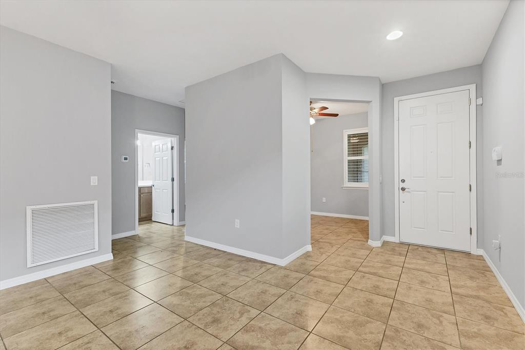 An entryway with light gray walls, tan tile flooring, and a white front door — 19010 MANGIERI STREET, VENICE, FL