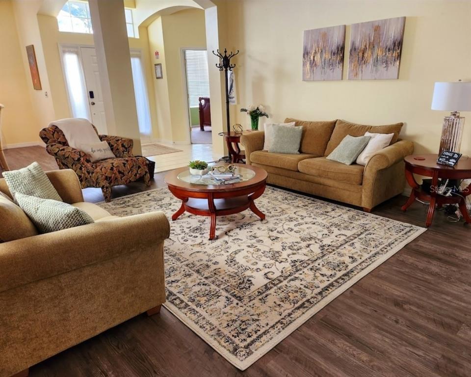 A living room features two tan sofas, a patterned armchair, and a round coffee table — 236 BOXWOOD DRIVE, DAVENPORT, FL