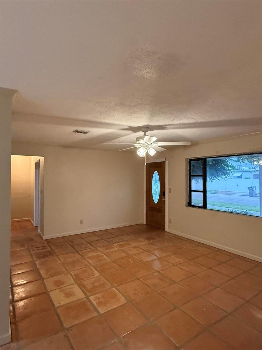 A living room features terracotta tile flooring, a ceiling fan, and a front entry door — 817 Elm Road, West Palm Beach FL 33409, WEST PALM BEACH, FL