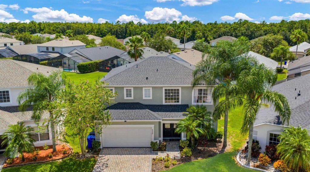 An aerial view of a two-story suburban house with a gray roof and paved driveway — 4817 CUMBRIAN LAKES DRIVE, KISSIMMEE, FL